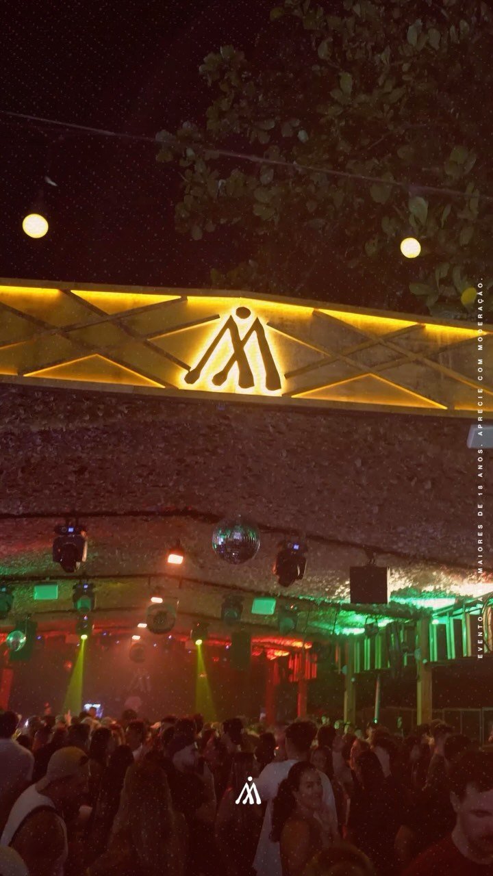 Palco da Aldeia Lagoa com luzes douradas à noite